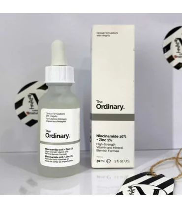 سرم نیاسینامید اوردینری اصل در کنار جعبه سفید برند The Ordinary 30 میل از مهوین شاپ